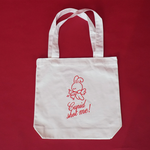 White tote bag with red text and bunny graphics on a red background